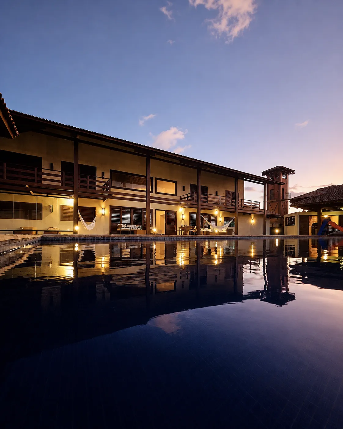 Casa Amarela ao entardecer refletida na piscina